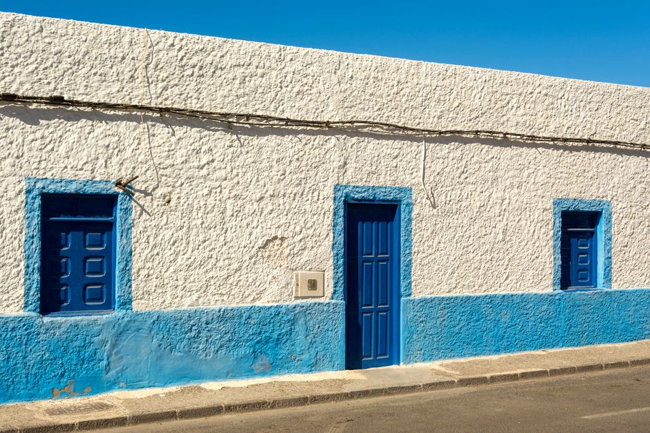 Blue and white painted house front under a clear sky
