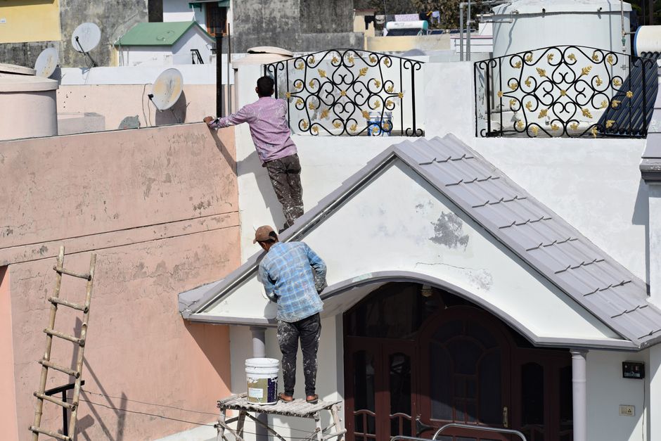 Two painters working on a building exterior