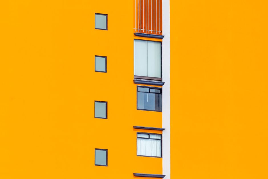 Orange painted house wall with small windows